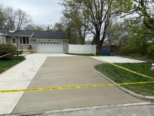 Concrete walkway connecting a driveway to a front entry