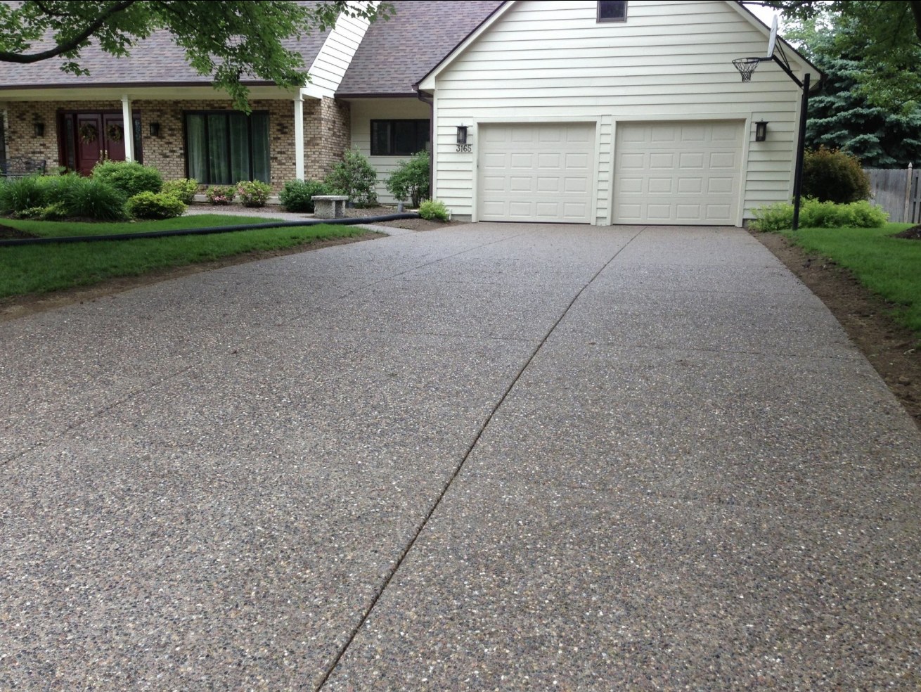 Exposed aggregate concrete driveway leading to a two-car garage in South Jersey