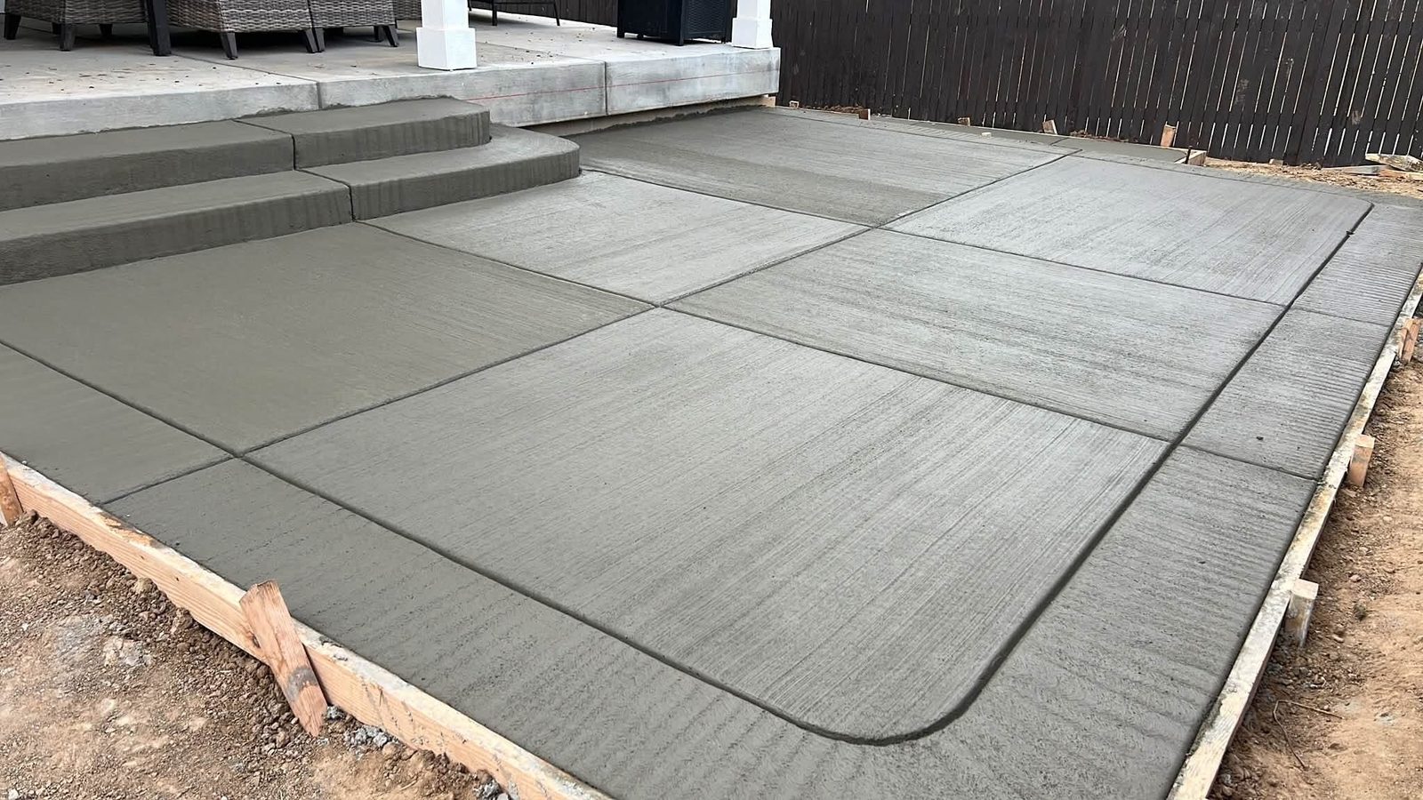 Brushed concrete patio with control joints and curved detail