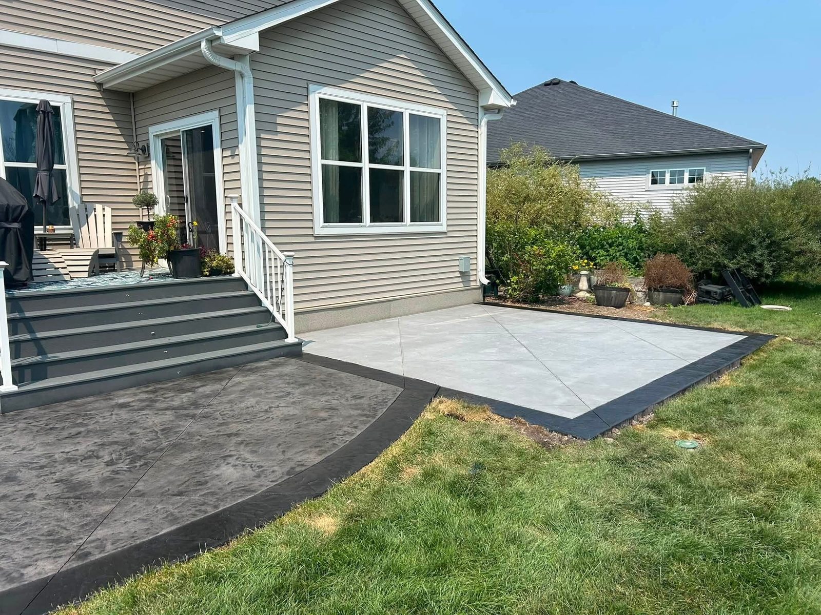 Two-tone concrete backyard patio with decorative border