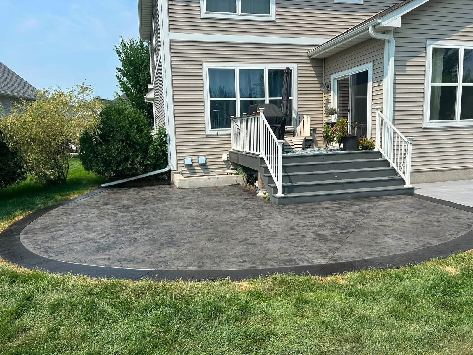 Wide view of a curved stamped concrete backyard patio