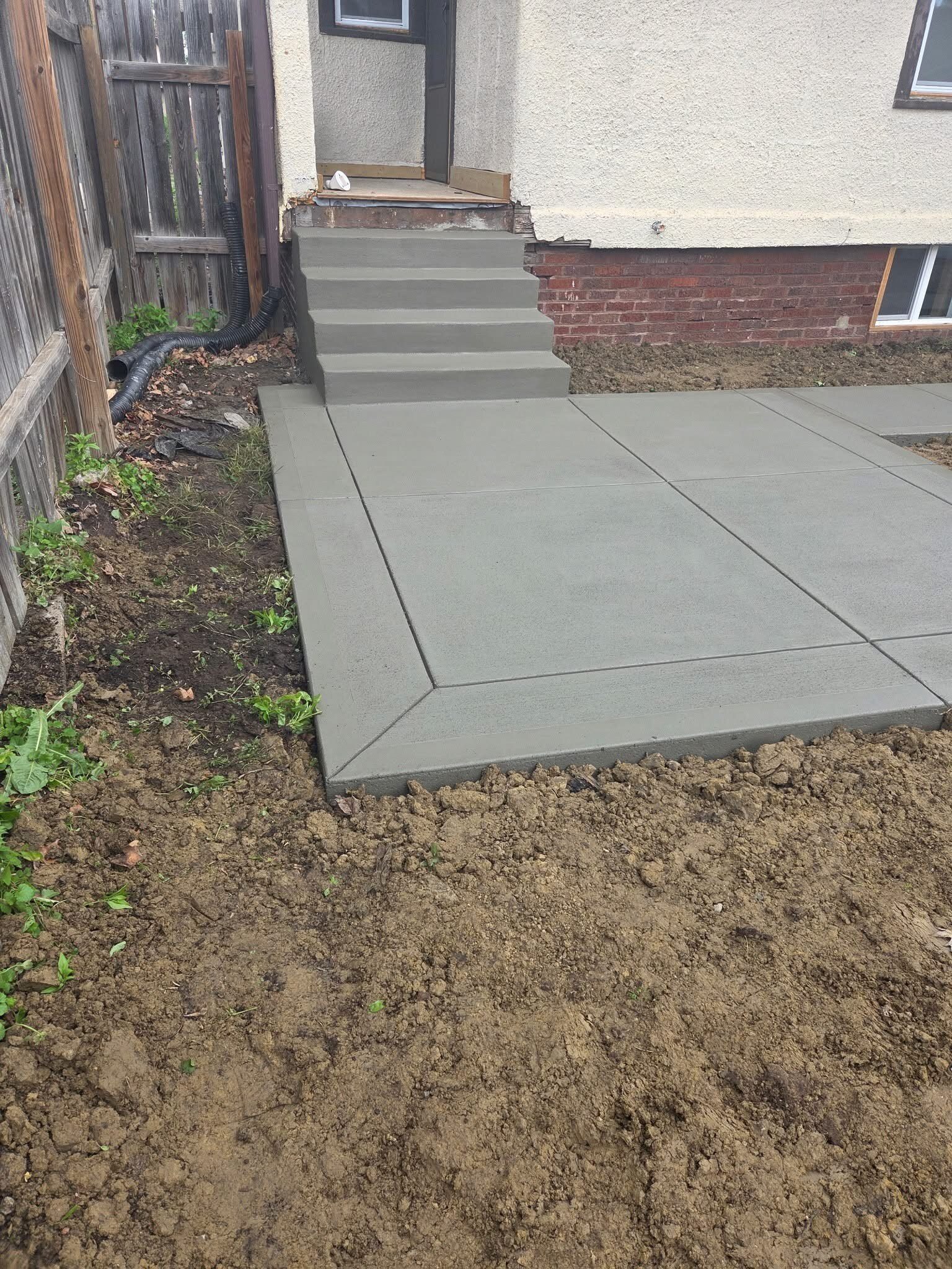 New concrete patio leading to finished exterior steps