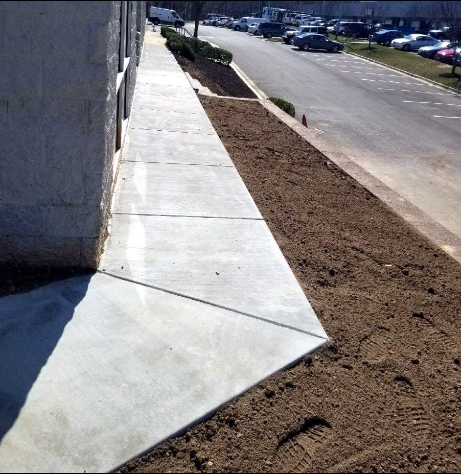 New commercial concrete sidewalk beside a parking lot