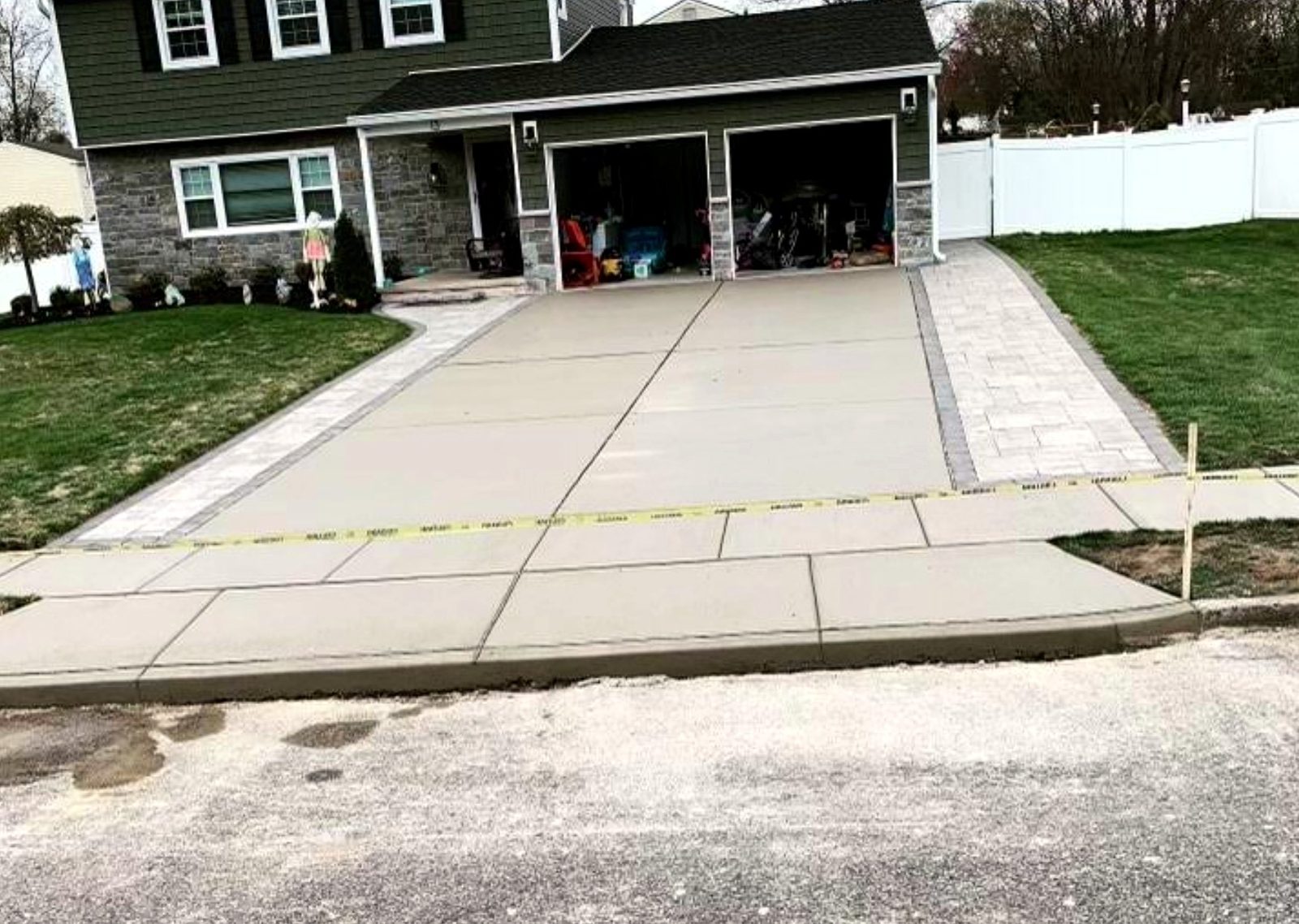 Wide concrete driveway apron finished at the street edge