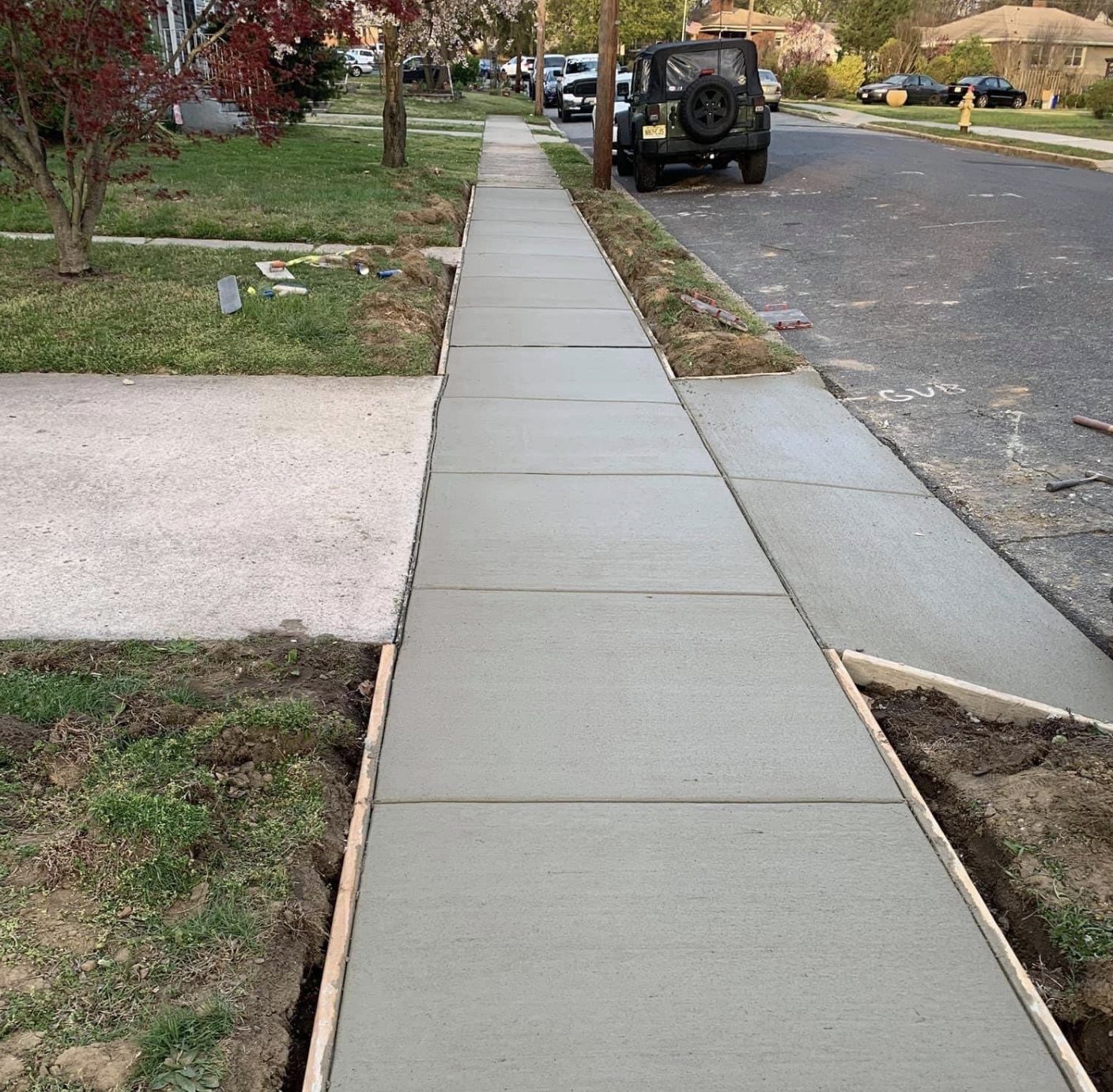Long run of new concrete sidewalk with even control joints