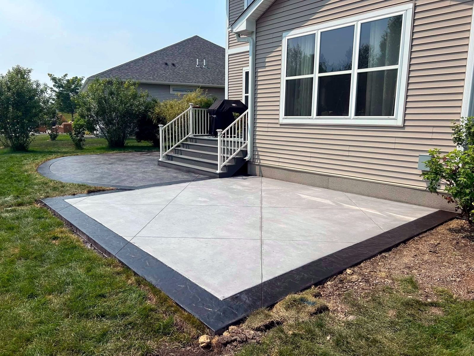 Concrete patio with a curved dark decorative border