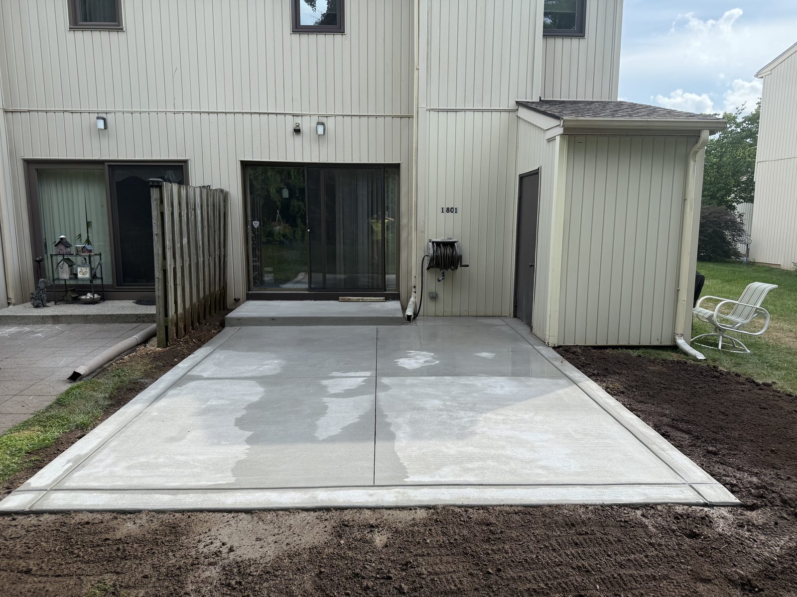 Large poured concrete patio finished across a backyard