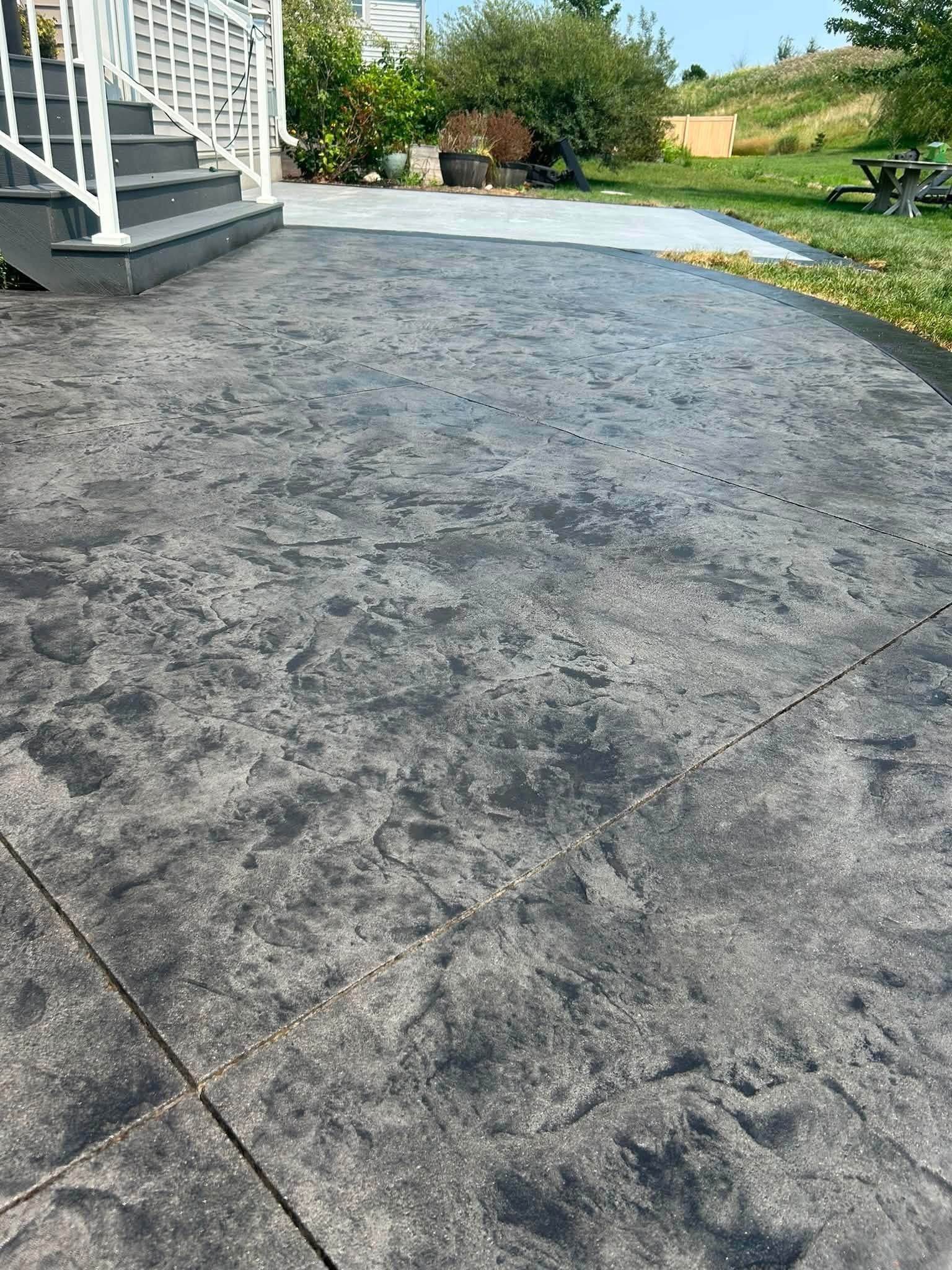 Wide stamped concrete patio with a bordered perimeter