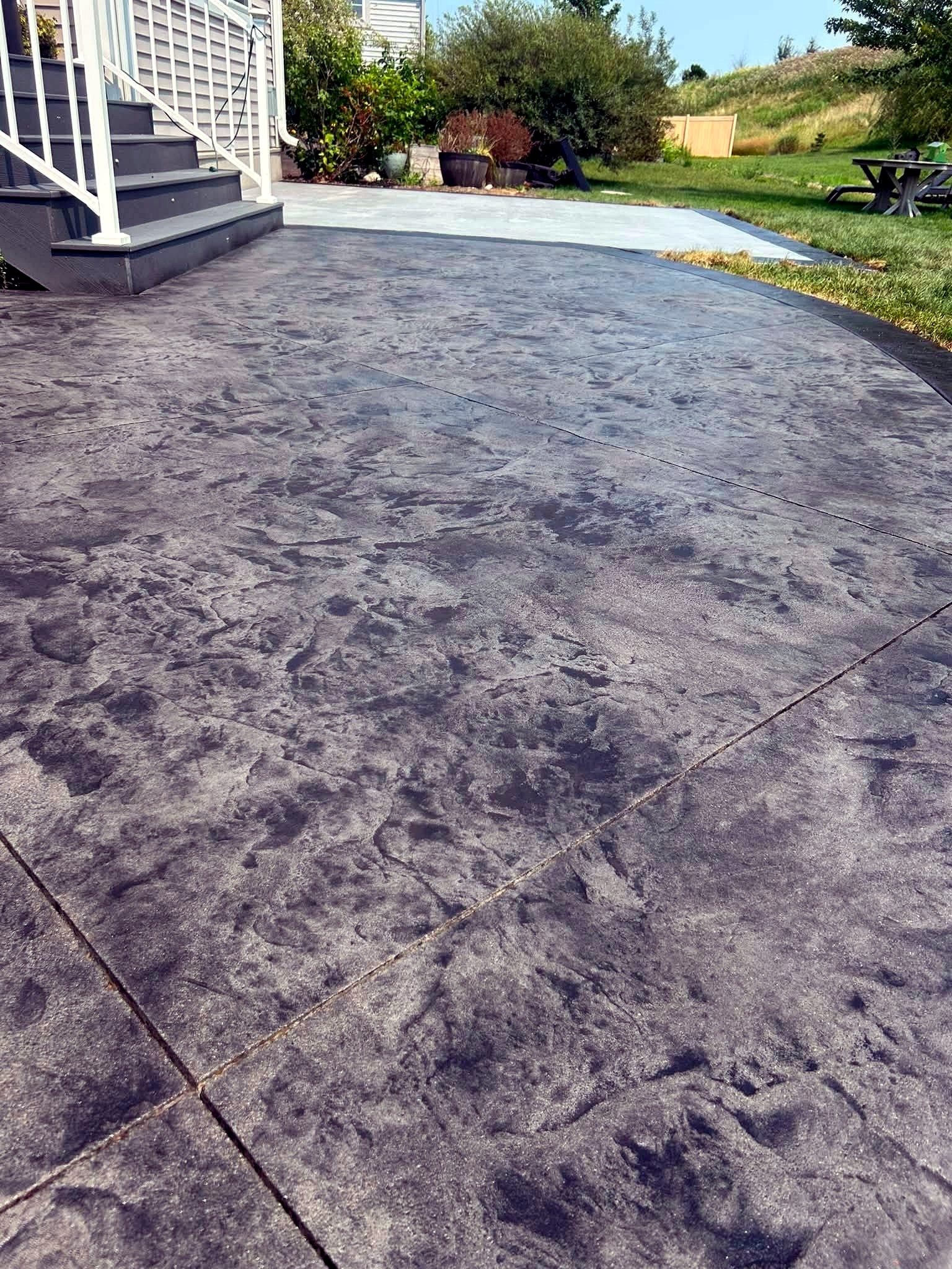 Stamped concrete patio finished with a slate texture and color