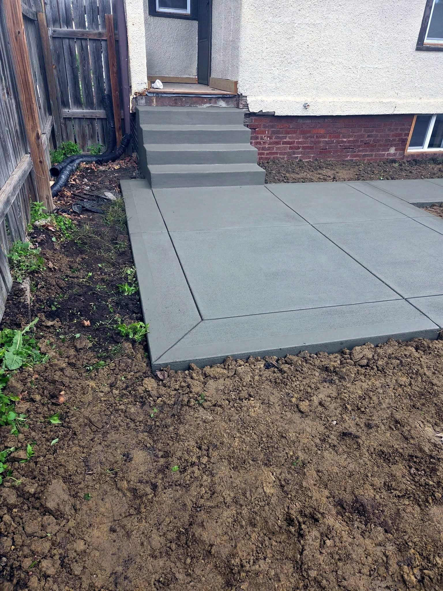 Concrete steps joining a new side walkway at a rear entry